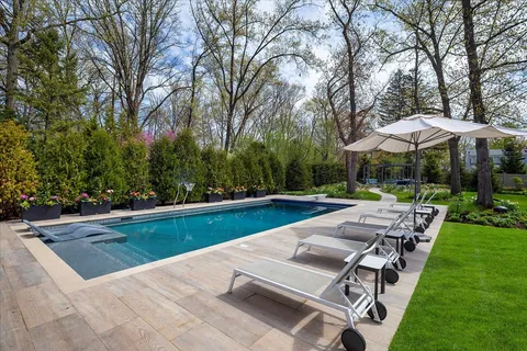 a view of a chair and table in backyard of the house