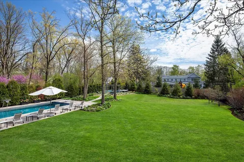 an aerial view of a house with swimming pool and big yard
