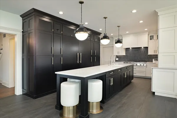 a large kitchen with stainless steel appliances kitchen island granite countertop a stove a sink and a refrigerator