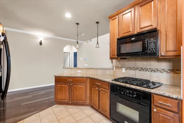a kitchen with stainless steel appliances granite countertop a stove a sink and a microwave