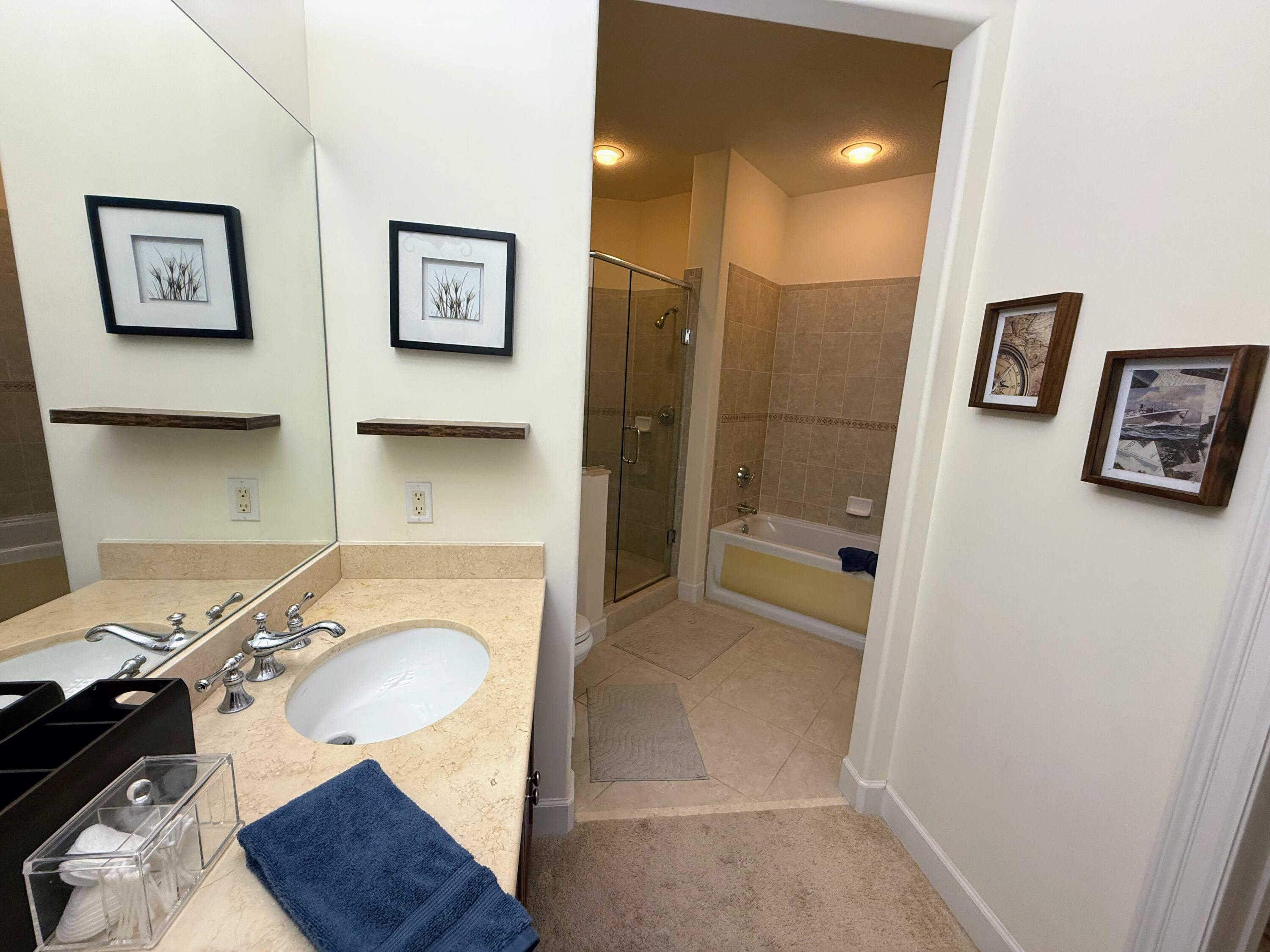 20 Orange Avenue, Unit 9 Fort Pierce, FL 34950 - Photo 76 of 92 a bathroom with a granite countertop sink and a mirror