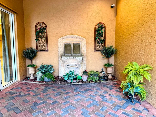 a vase with flowers sitting on a table in front of a house