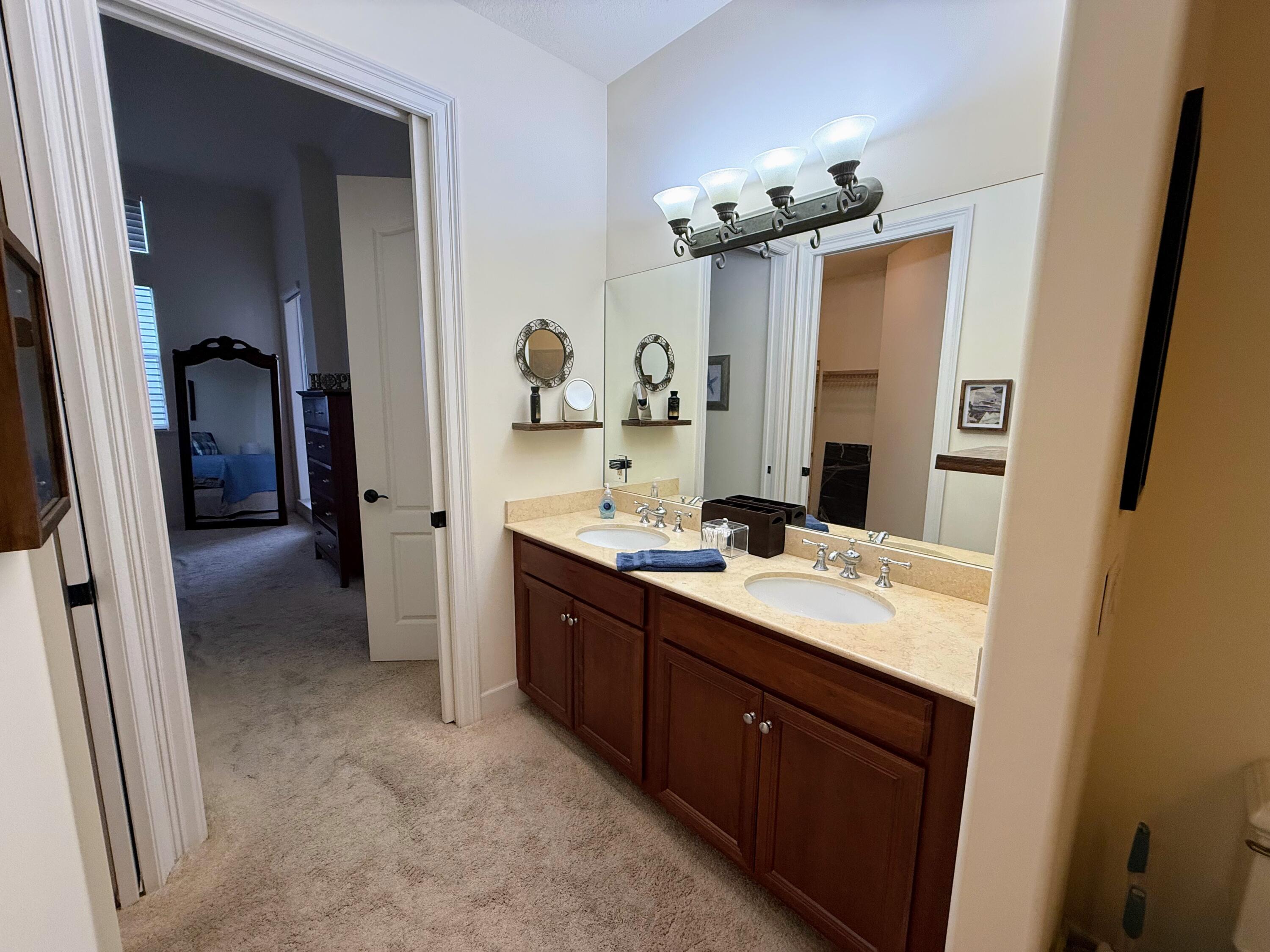 20 Orange Avenue, Unit 9 Fort Pierce, FL 34950 - Photo 83 of 92 a spacious bathroom with a double vanity sink a mirror and a shower