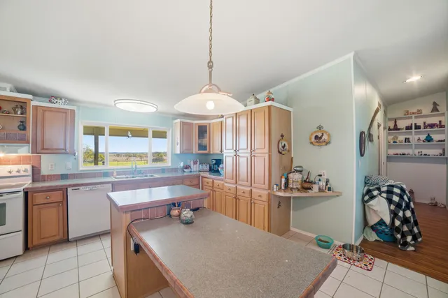 a kitchen with stainless steel appliances a table and chairs in it