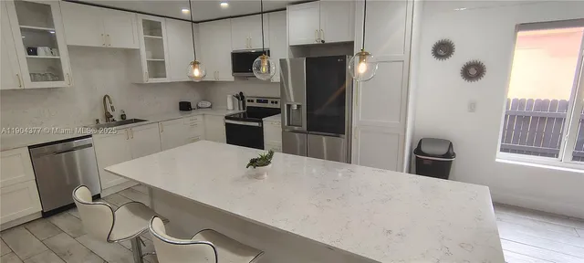 a kitchen with stainless steel appliances a refrigerator and a stove top oven