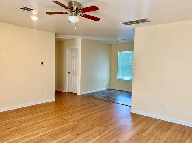 a view of an empty room with wooden floor