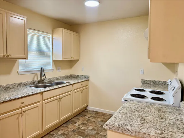 a kitchen with a sink and a stove top oven