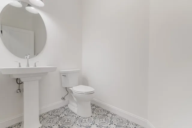 a bathroom with a toilet and a mirror