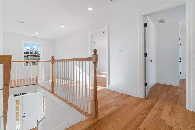 a view of a hallway with entryway and wooden floor