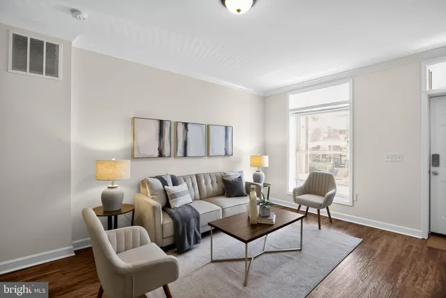 a living room with furniture and a wooden floor