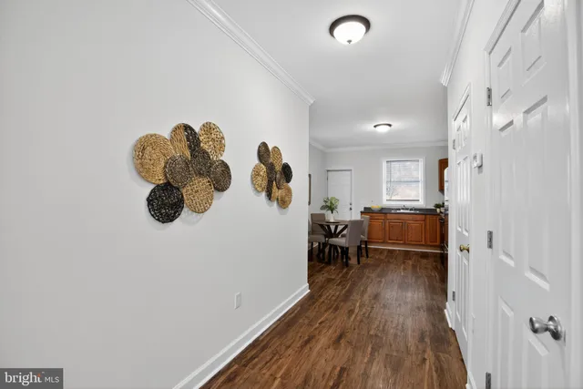 a kitchen with stainless steel appliances granite countertop a stove top oven a dining table and chairs with wooden floor