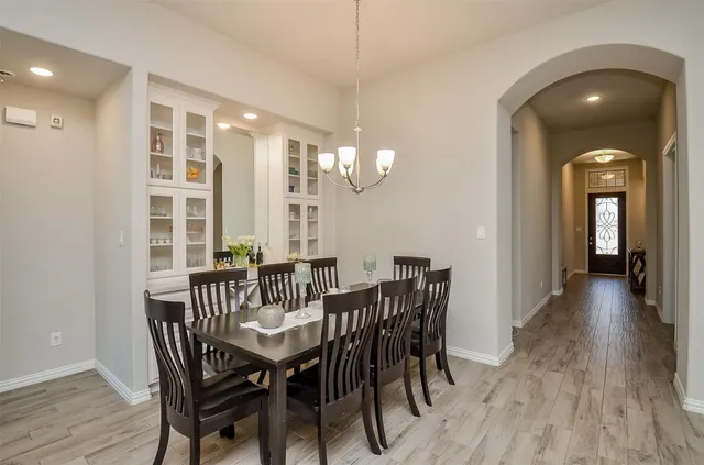 a view of a dining room with furniture a chandelier and wooden floor