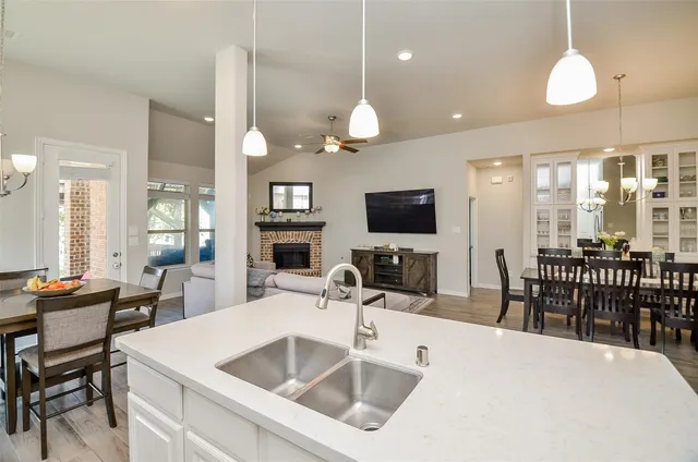 a kitchen with a sink a counter space appliances and cabinets