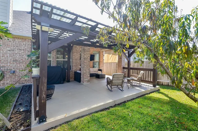 a patio with table and chairs and potted plants