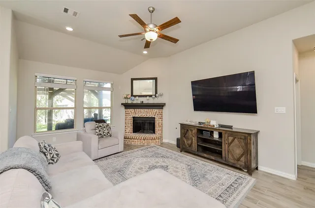 a living room with furniture kitchen view and a wooden floor
