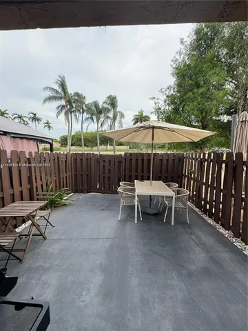 a view of a chairs and table in the back yard of the house
