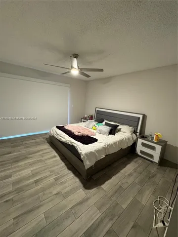 a bedroom with a bed and a ceiling fan