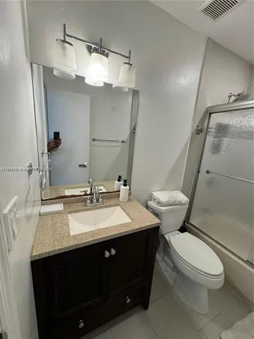 a bathroom with a sink vanity mirror and toilet