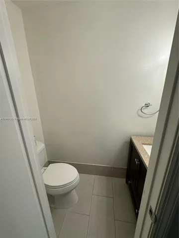a white toilet sitting next to a wooden cabinet