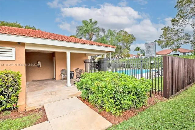 a view of a house with brick walls and a yard with plants