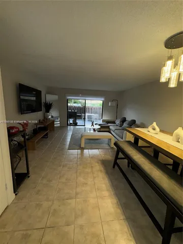 a living room with furniture a flat screen tv and kitchen view