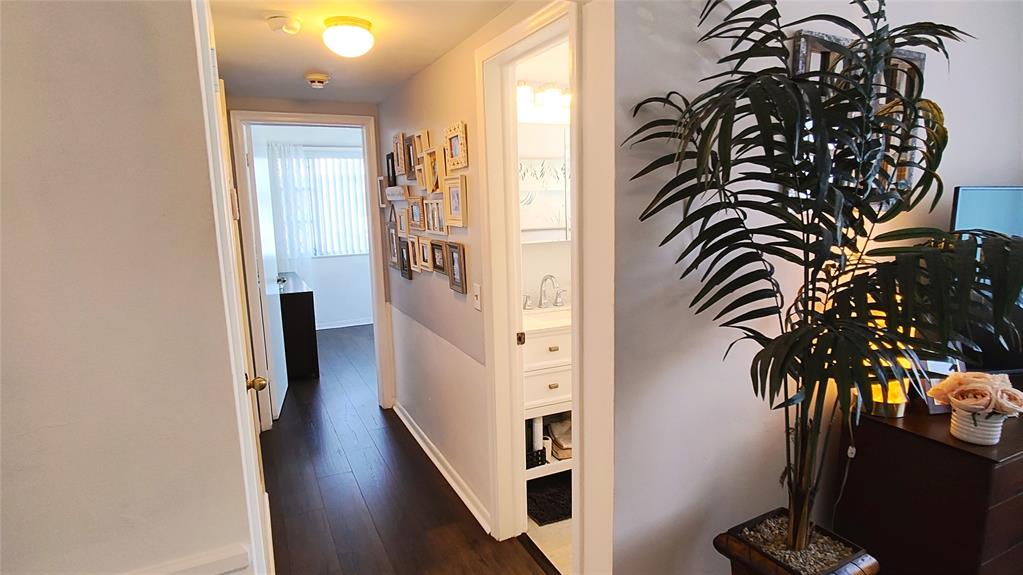 412 South Cypress Road, Unit 222 Pompano Beach, FL 33060 - Photo 14 of 19 a view of a hallway with wooden floor and a potted plant