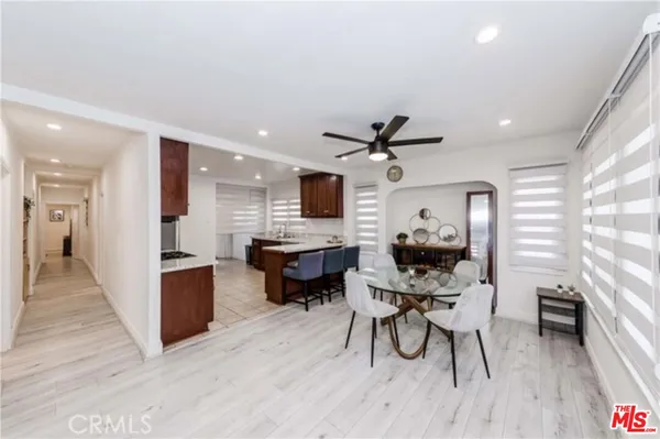 a living room with furniture a wooden floor and a kitchen view