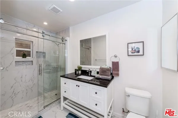 a bathroom with a double vanity sink toilet and shower