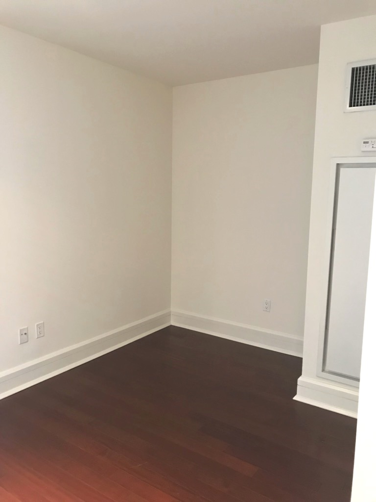60 Riverside Boulevard, Unit 615 Manhattan, NY 10069 - Photo 2 of 15 an empty room with wooden floor and door