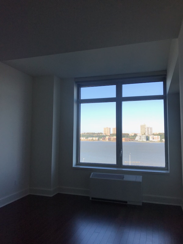 60 Riverside Boulevard, Unit 615 Manhattan, NY 10069 - Photo 6 of 15 an empty room with wooden floor and windows