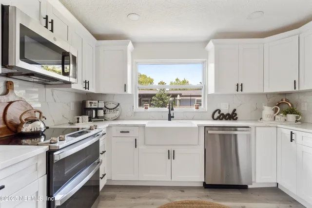 a kitchen with stainless steel appliances a stove a microwave and cabinets