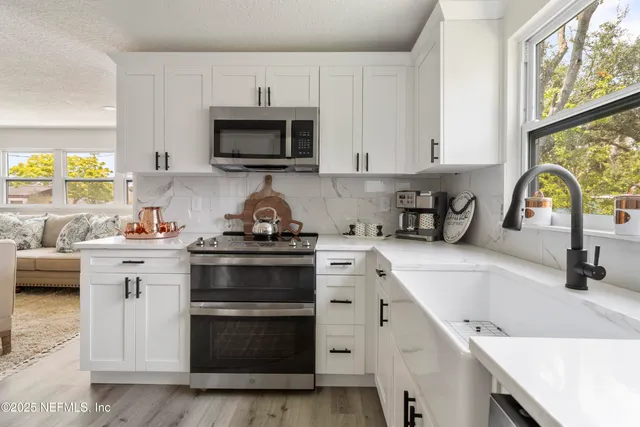 a view of a hallway with wooden floor and a living room