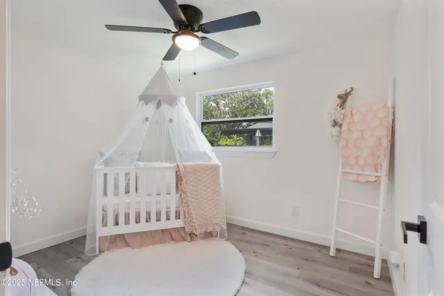a bedroom with a bed a window and a potted plant