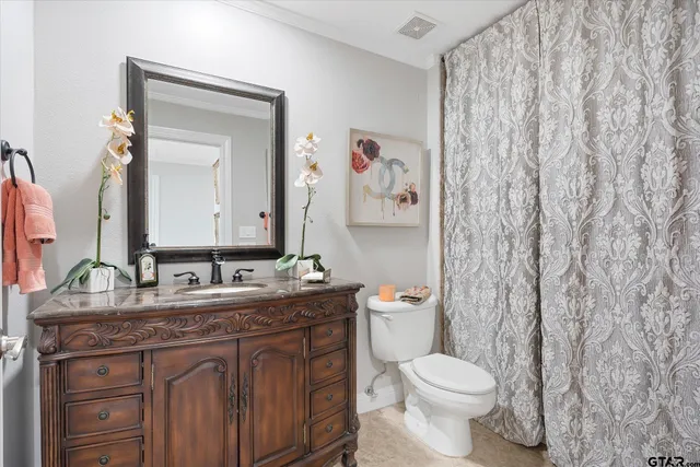 a bathroom with a granite countertop toilet sink and mirror