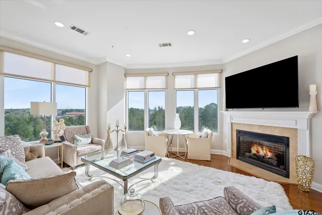 a living room with furniture a large window and a fireplace