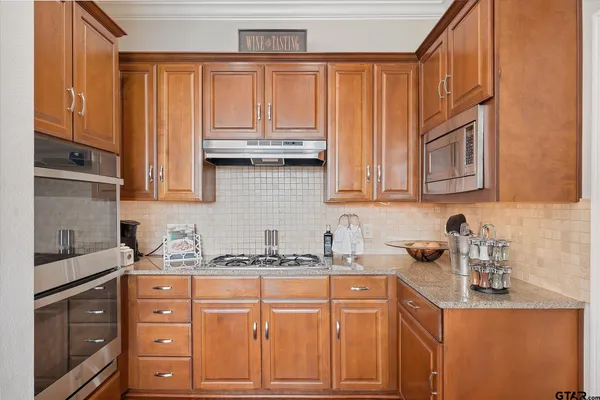 a kitchen with stainless steel appliances granite countertop a sink and cabinets