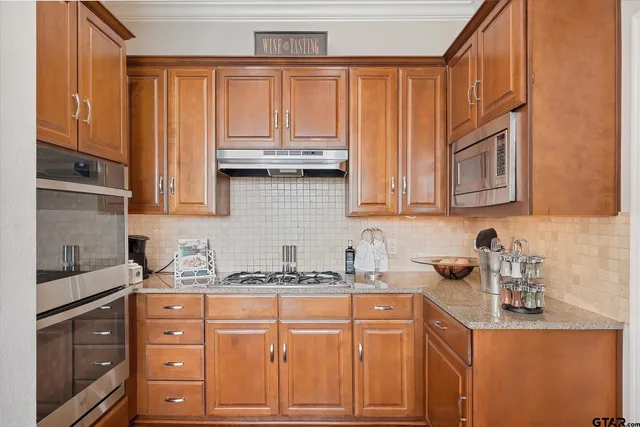 a kitchen with stainless steel appliances granite countertop a sink and cabinets