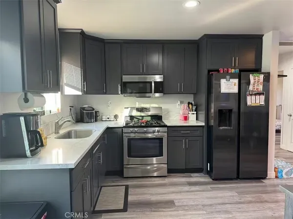 a kitchen with stainless steel appliances granite countertop a refrigerator stove and sink