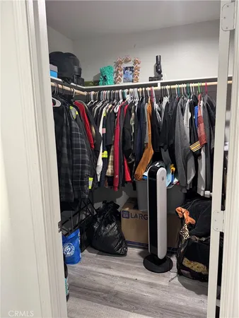 a view of walk in closet with clothes and shoes