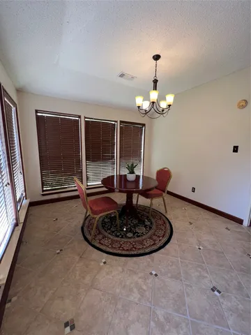 a view of a room with a chandelier and wooden floor