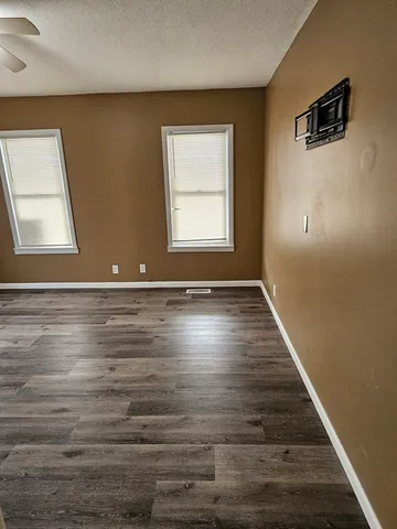 a view of room with window and wooden floor