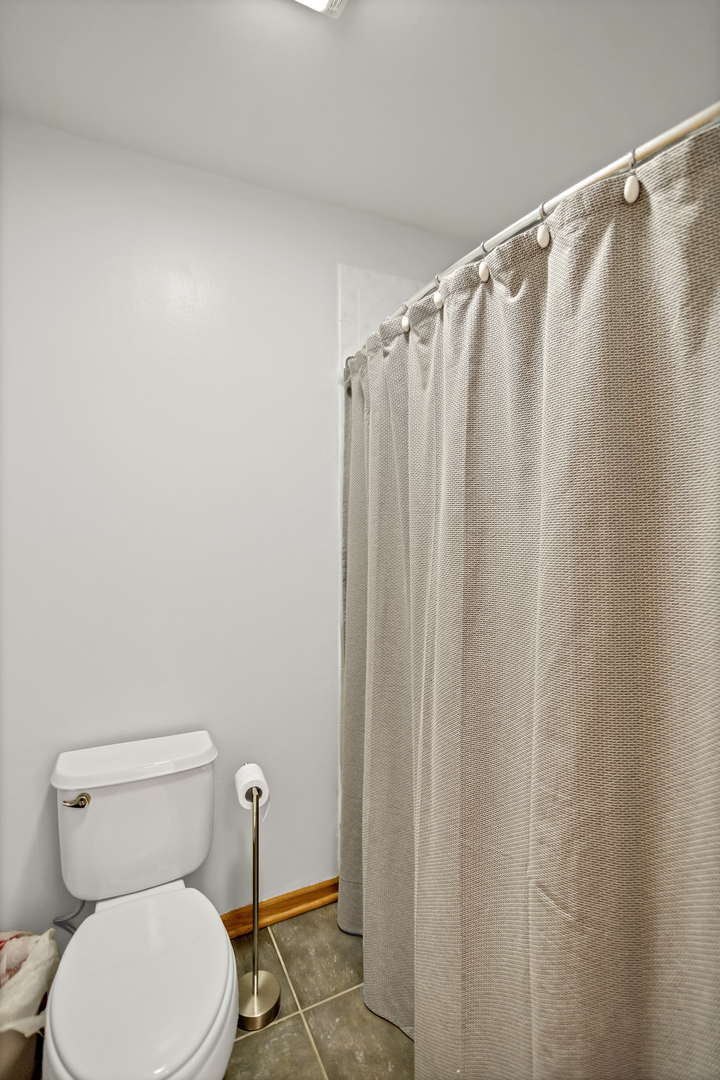 848 Pheasant Trail St. Charles, IL 60174 - Photo 26 of 30 a white toilet sitting next to a shower curtain