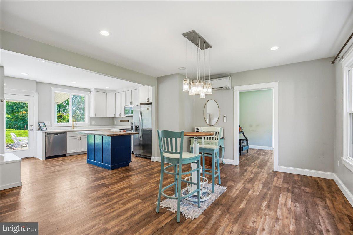 16146 Thomas Road Piney Point, MD 20674 - Photo 12 of 70 a open kitchen with stainless steel appliances granite countertop a stove top oven a sink dishwasher a dining table and chairs with wooden floor