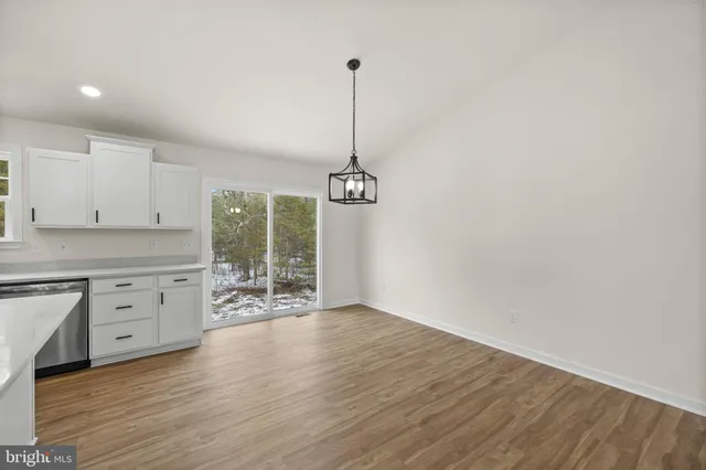 a kitchen with dishwasher wooden floor and white appliances