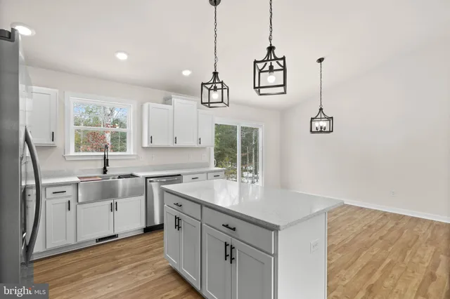 a kitchen with white cabinets and sink