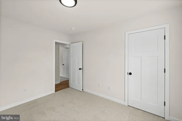 a view of a big room with windows and chandelier fan