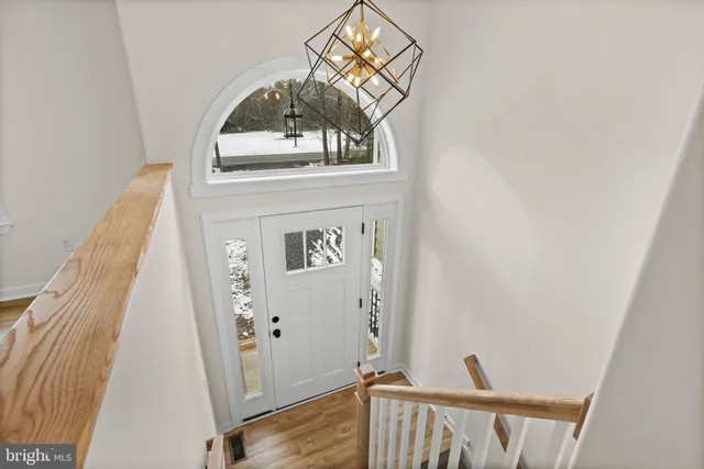 a view of a hallway with wooden floor and entryway
