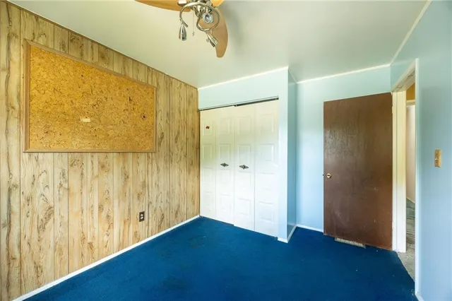 an empty room with a window and a ceiling fan