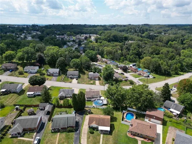 an aerial view of a house with swimming pool and mountains