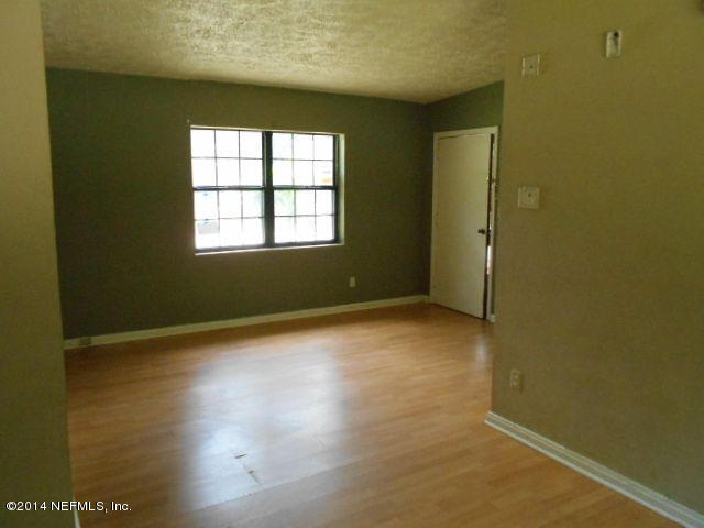 2916 Kent Road Jacksonville, FL 32216 - Photo 5 of 15 an empty room with wooden floor and windows